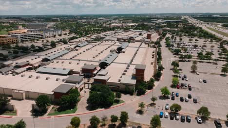 Round-Rock-Premium-Outlets-Aerial-Drone-orbit-high-above-shops-in-parking-lot-on-sunny-summer-day-in-Texas-in-4k