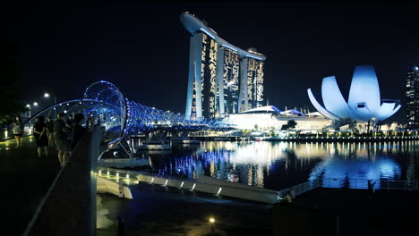 Singapurer-Und-Touristen-Genießen-Einen-Abend-In-Der-Marina-Bay,-überqueren-Die-Helix-Brücke-Und-Genießen-Die-Aussicht