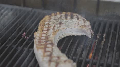 Pork-chop-closeup-on-grill,-smoking-barbeque-meal