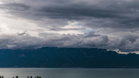 Nubes-Y-Niebla-Volando-Sobre-El-Tranquilo-Lago-Leman-En-Suiza-Con-Majestuosos-Alpes-Franceses-En-El-Fondo