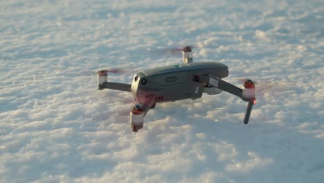 Drohnenpropeller-Drehen-Sich,-Während-Sie-Zur-Goldenen-Stunde-Auf-Gefrorenem-Boden-Stehen
