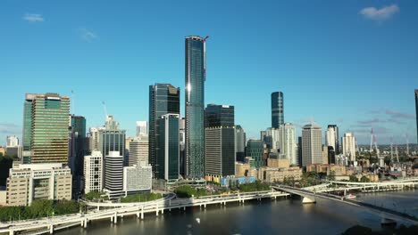 Aerial-drone-shot-of-Brisbane's-cityscape-from-West-End,-as-the-camera-gracefully-flies-backwards,-revealing-a-large-apartment-building-in-the-heart-of-West-End