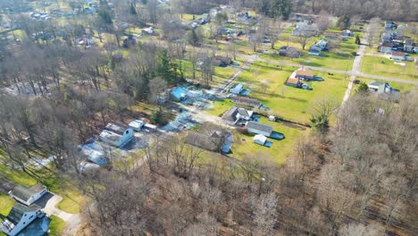 An-aerial-shot-of-a-small-rural-neighborhood-that-is-filled-with-houses-and-dead-winter-trees