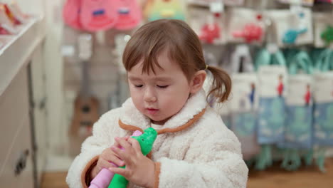 Süßes-3-jähriges-Mädchen-Staunt-über-Krokodil-Plastikspielzeug-In-Einem-Einkaufszentrum