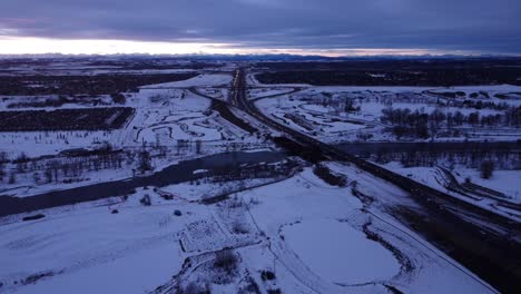 Aerial-view-of-snowy-traffic-flow-in-canadian-winter:-drone-footage-of-winter-driving