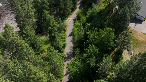 Top-down-aerial-shot-of-cyclists-riding-along-the-Spokane-River-Centennial-State-Park-Trail