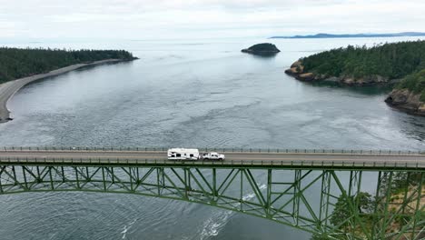 Tracking-shot-of-a-truck-hauling-an-RV-over-Deception-Pass-in-Washington-State