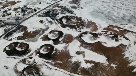 Skútustaðagígar-Craters-of-Iceland,-Surrounded-by-Snowy-Lands-and-Wetlands-of-Lake-Myvatn-Area,-Famous-Natural-Phenomenon,-Touristic-Attraction-and-Geology-Site,-Aerial-Orbit-View