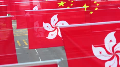 Los-Vehículos-Circulan-Por-La-Calle-Mientras-Pasan-Junto-A-Las-Banderas-De-La-República-Popular-De-China-Y-El-Sar-De-Hong-Kong-Se-Exhiben-Antes-Del-1-De-Julio-Aniversario-De-La-Entrega-De-Hong-Kong-A-China