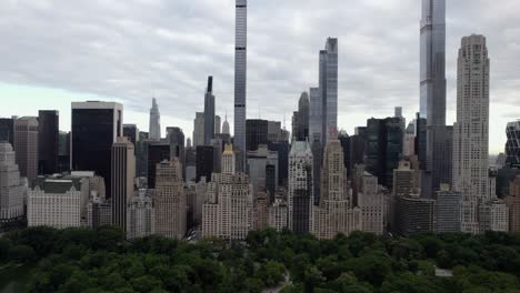 Aerial-view-over-the-Central-Park,-towards-supertall-skyscrapers-in-MIdtown,-New-York,-USA---tilt,-drone-shot