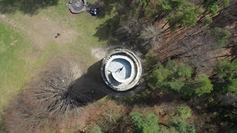 Top-Down-Aerial-View,-Lonely-Girl-Spinning-With-Split-Hands-on-Top-of-Medieval-Tower-on-Sunny-Day,-Ascending-Drone-Shot
