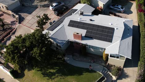 Solar-panels-on-a-home-rooftop-for-clean,-efficient,-renewable-energy---aerial-descending-spinning-view