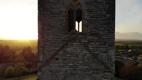 Eine-Nach-Oben-Aufsteigende-Luftaufnahme-Des-Kirchturms-Von-Burrow-Mump-Zeigt-Einen-Wunderschönen-Sonnenuntergang