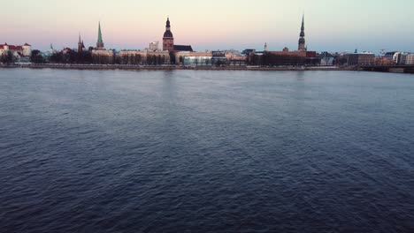 Wasseroberfläche-Des-Flusses-Daugava-Und-Skyline-Der-Stadt-Riga,-Luftaufnahme