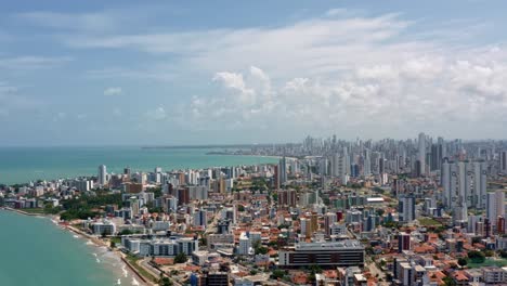 wide-aerial-shot-of-the-tropical-capital-of-Joao-Pessoa-from-intermares-beach-in-Cabedelo,-Brazil-with-skyscrapers-along-the-coastline-in-the-state-of-Paraiba-on-a-warm-sunny-summer-day