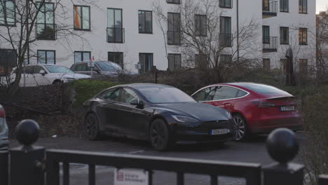 Tesla-electric-vehicle-cars,-parked-in-luxury-area,-Stockholm,-handheld