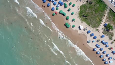 rising-bird's-eye-shot-of-intermares-beach-in-Cabedelo,-Brazil-with-Brazilians-and-tourists-enjoying-the-ocean-near-the-costal-capitol-of-Joao-Pessoa-in-the-state-of-Paraiba-on-a-warm-sunny-summer-day