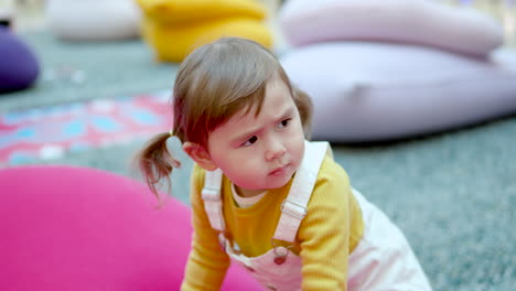 Cute-Little-Girl-With-Serious-Facial-Expression-At-The-Kids-Area-Of-A-Shopping-Mall