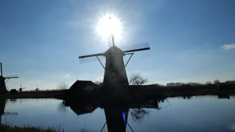 Silhouettenansicht-Der-Berühmten-Windmühlen-In-Kinderdijk,-Holland,-Neben-Einem-Ruhigen,-Reflektierenden-Fluss