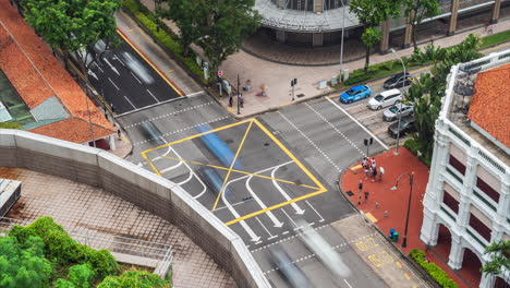 Tráfico-En-Movimiento-A-Través-De-La-Intersección-Del-Hotel-Carlton,-Centro-Comercial-De-La-Ciudad-De-Raffles,-Singapur