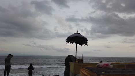 Hinduistische-Regenschirmsilhouette-Am-Strand-Von-Bali,-Balinesischer-Hinduismus-Mit-Gelben-Stoffen,-Die-Die-Ursprüngliche-Religion-Von-Der-Insel-Der-Götter,-Masceti,-Gianyar-Darstellen