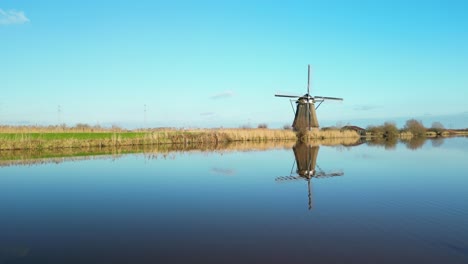 Beautiful-reflection-of-a-traditional-windmil-at-kinderdijk-on-a-bright-autumn-day