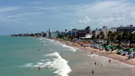 Dolly-Out-Luftaufnahme-Des-Intermares-Strandes-In-Cabedelo,-Brasilien,-Mit-Brasilianern-Und-Touristen,-Die-An-Einem-Warmen,-Sonnigen-Sommertag-Das-Meer-In-Der-Nähe-Der-Küstenhauptstadt-Joao-Pessoa-Im-Bundesstaat-Paraíba-Genießen
