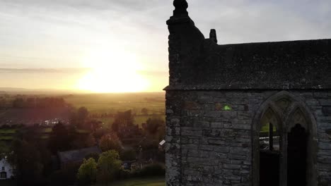 Luftaufnahme-Der-Kirchenruinen-Von-Burrow-Mump-Mit-Einem-Atemberaubenden-Sonnenuntergang-über-Den-Somerset-Ebenen-Als-Hintergrund