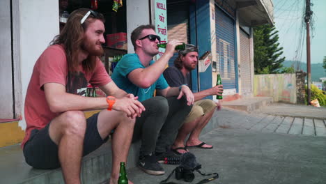Jungs,-Die-Während-Ihres-Urlaubs-Am-Straßenrand-Sitzen-Und-Ein-Bier-Trinken