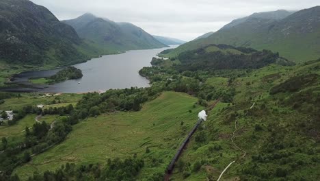 Aerial-follows-steam-train-along-Loch-Shiel-in-Scottish-highlands