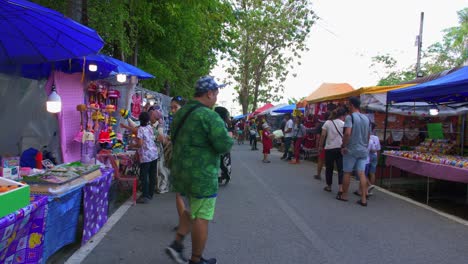 Static-shot-of-locals-and-tourists-thronging-to-buy-local-merchandise-in-Khlong-Hae-floating-market-in-Songkhla-province,-Thailand-at-daytime
