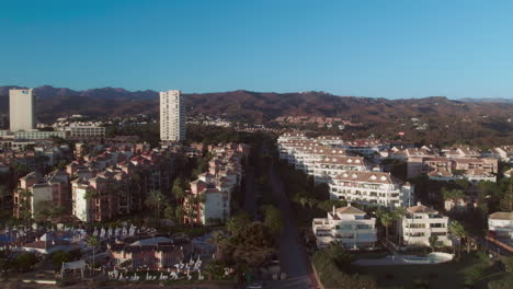 Aerial-moving-backwards-from-coastline-apartments-to-the-Mediterranean-sea-near-Marbella,-Spain