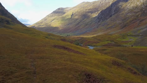 Low-flight-down-river-valley-to-hiker-in-Scottish-highland-mountains