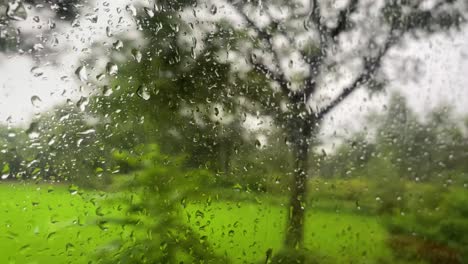 Rain-droplets-on-a-bus-window-driving-on-bumpy-road