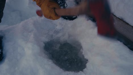 Man-Is-Holding-An-Axe-Making-A-Hole-In-A-Frozen-Lake