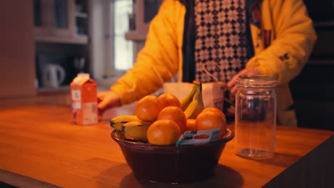 Der-Mann-Legt-Frische-Orangenfrüchte-Auf-Eine-Schüssel-Auf-Einem-Holztisch