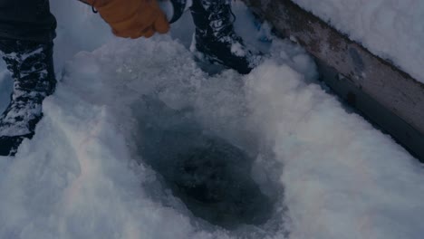 Man-Is-Filling-A-Thermal-Tumbler-With-Frozen-Lake-Water