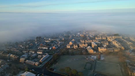Cinematic-aerial-view-of-town-city-with-residential-buildings-in-morning-fog-and-mist