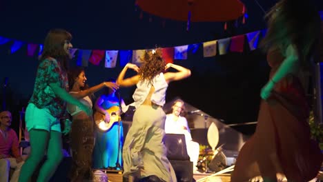 Mujeres-Bailando-Por-La-Noche-Con-Ropa-Colorida-De-Verano,-Evento-Musical-Enérgico