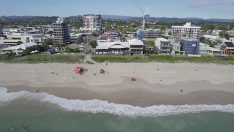 Holiday-Apartments-Under-Construction-With-Tourists-Enjoying-Summer-At-The-Palm-Beach-In-Gold-Coast,-Queensland