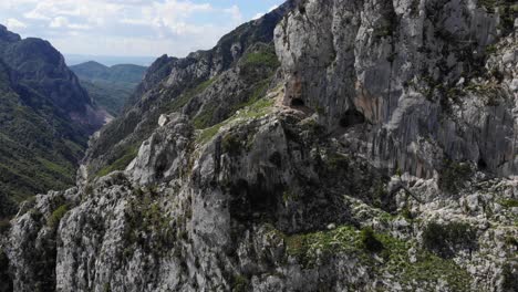 Aerial-rising-next-to-rock-wall,-Lake-Bovilla,-Albania