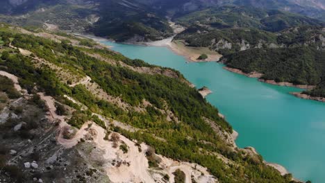 Aerial-flying-towards-turquoise-waters-of-lake-Bovilla,-Abania