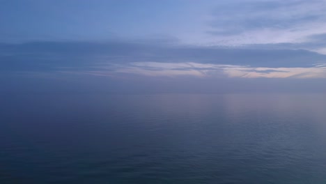 Ruhige-Meereswellen-Nach-Sonnenuntergang-Mit-Bewölktem-Himmel