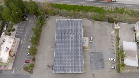 Birds-Eye-Aerial-View,-Large-Solar-Panels-Array-on-Rooftop-of-Business-Building