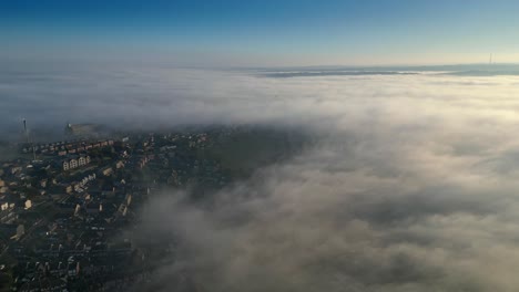 Vista-Aérea-Cinematográfica-De-Nubes-Bajas-En-La-Mañana-De-Sol-De-Una-Pequeña-Ciudad-Del-Reino-Unido