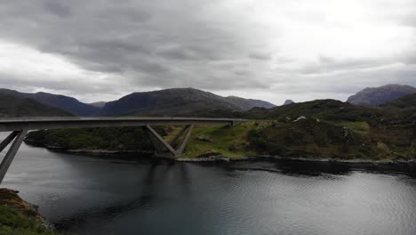 Aerial-forward-shot-looking-across-to-the-Kylescu-Bridge-in-the-Scottish-Highlands-with-a-moody-cloudy-sky