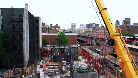 Aerial-view-passing-a-crane-lifting-materials-at-a-construction-site-in-New-York