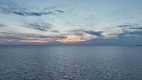 Mavic-Drone-seen-flying-into-sunset-along-the-European-coastline-at-last-light