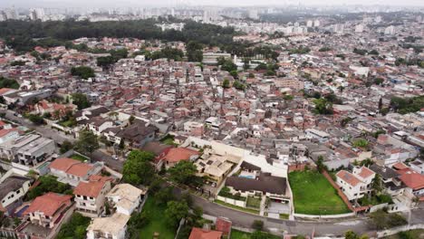 Aerial-view-over-wealthy-homes-towards-poverty-dwellings-in-cloudy-Sao-Paulo,-Brazil