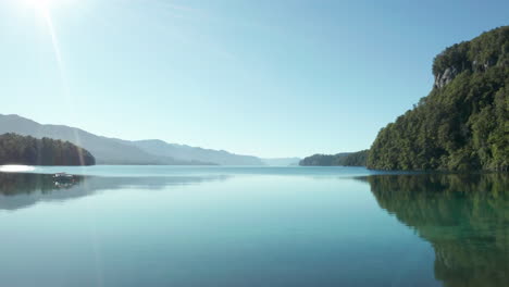 AERIAL---Through-trees-onto-Correntoso-Lake,-Neuquen,-Argentina,-forward-reveal